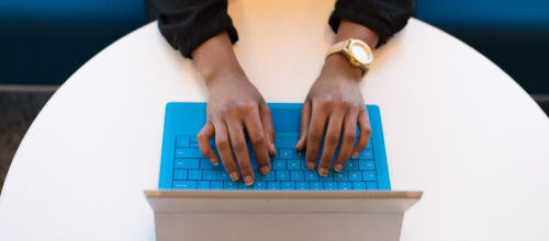 hands reaching out to type on a tablet keyboard