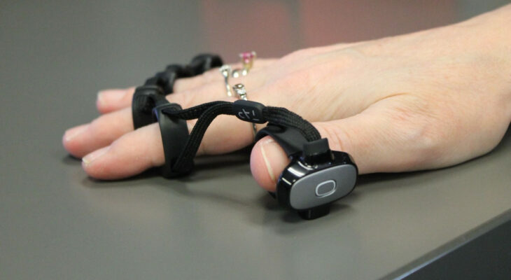 A hand wearing a virtual keyboard device