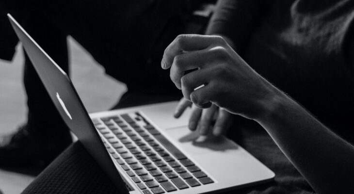 A black and white image of a person using a laptop