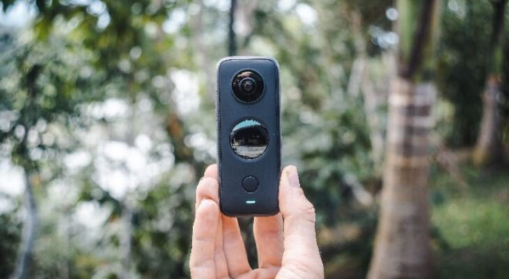 A hand holds a 360 degree camera