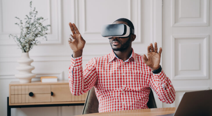 A man sitting in an office uses a virtual reality headset