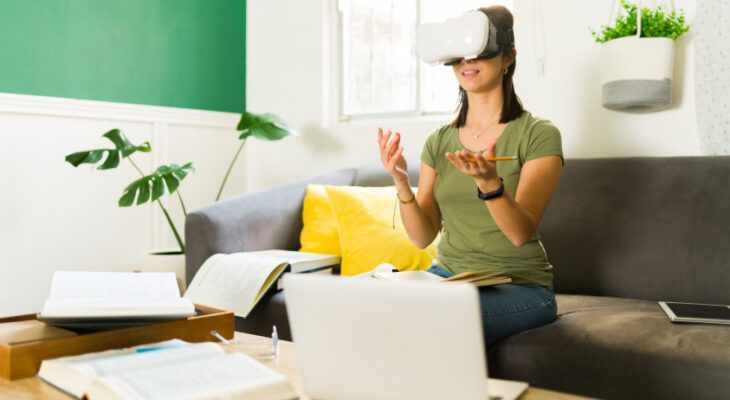 A woman with a VR headset on gestures to something in virtual reality