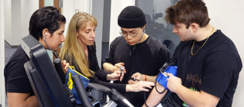 Students practice taking blood pressure under supervision during a kinesiology lab at the University of Michigan.