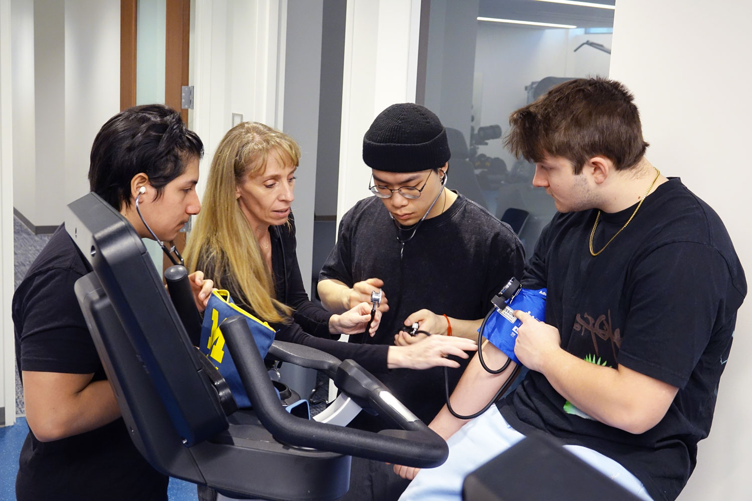 Students practice taking blood pressure under supervision during a kinesiology lab at the University of Michigan.