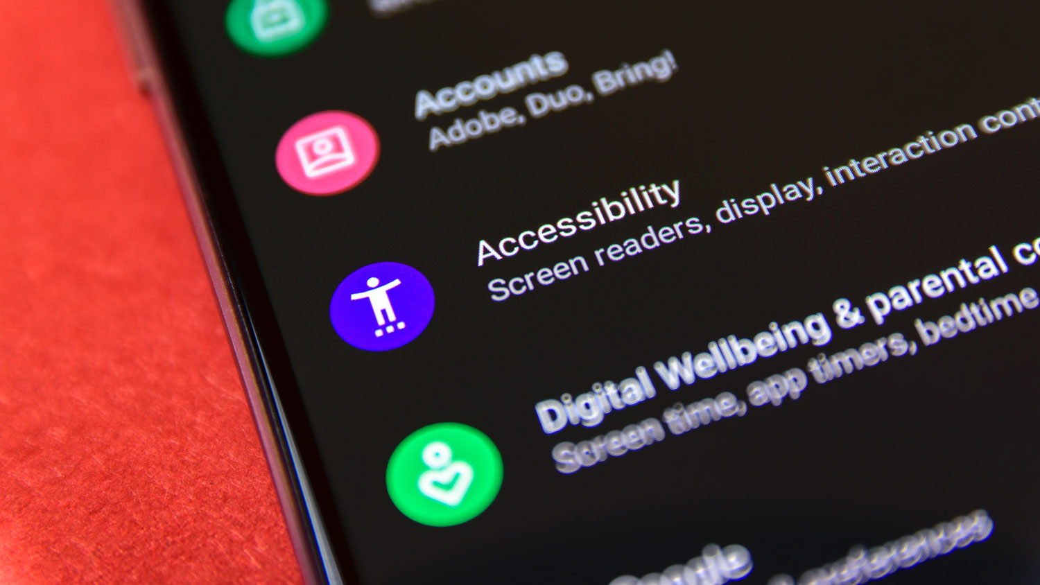 A smartphone screen displays the "Accessibility" settings option, including a purple icon and text mentioning screen readers and display settings.