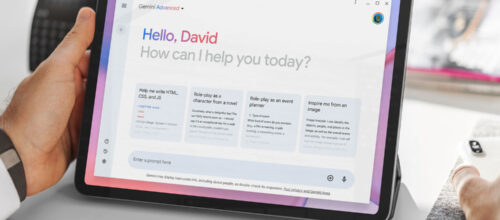 A tablet is held on a table, featuring a prompt page for the Google Gemini artificial intelligence tool. The text on the page says, "Hello, David. How can I help you today?"