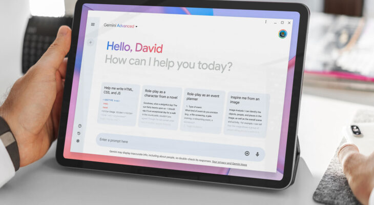 A tablet is held on a table, featuring a prompt page for the Google Gemini artificial intelligence tool. The text on the page says, "Hello, David. How can I help you today?"